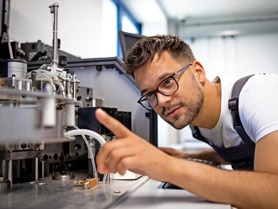 Ein Mann arbeitet an der Elektronik einer Maschine