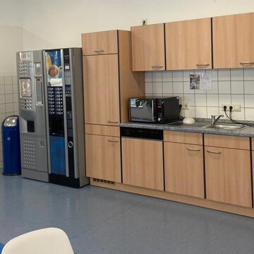 Helle, voll ausgestattete Teilnehmerküche mit Getränkeautomaten und Mikrowelle.