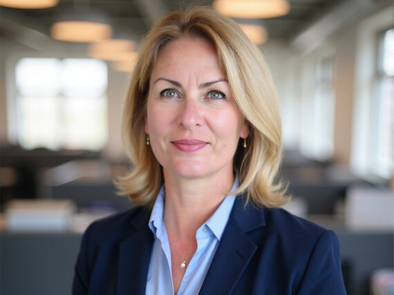 Coach Anna Illmer Porträt einer blonden Frau mit Blazer, die freundlich in die Kamera lächelt.