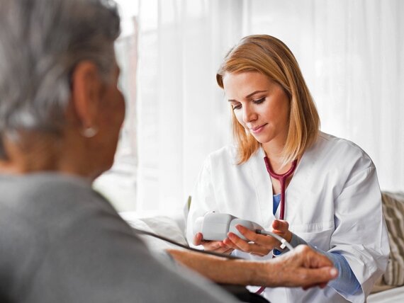 Eine junge Ärztin untersucht eine Seniorin
