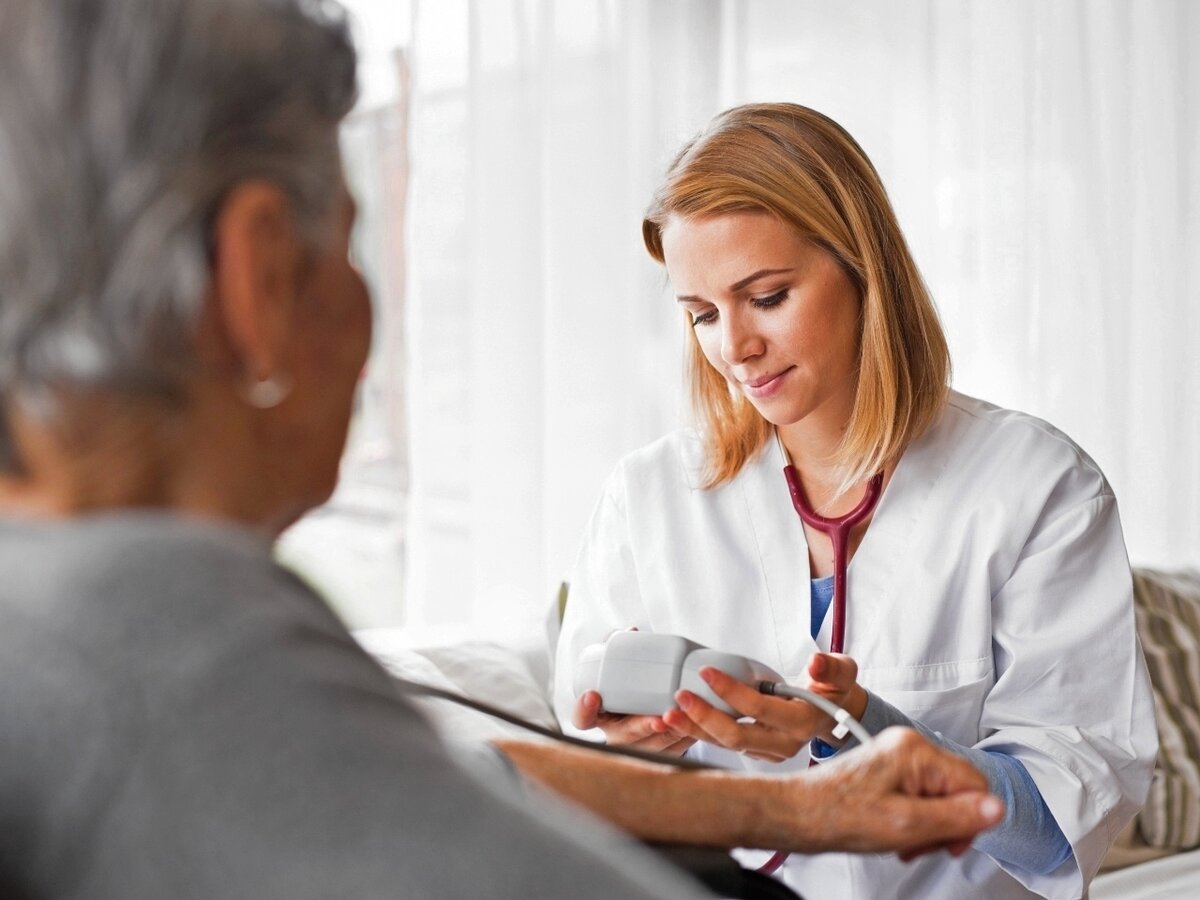 Eine junge Ärztin untersucht eine Seniorin