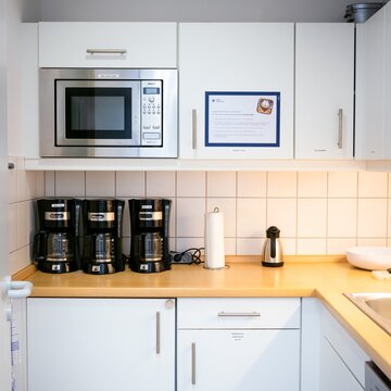 Eine voll ausgestattete Küche mit weißen Schränken.