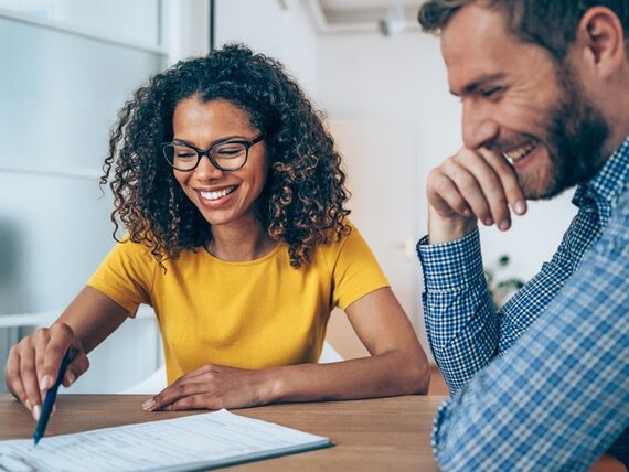 Eine Frau und ein Mann füllen Dokumente aus.