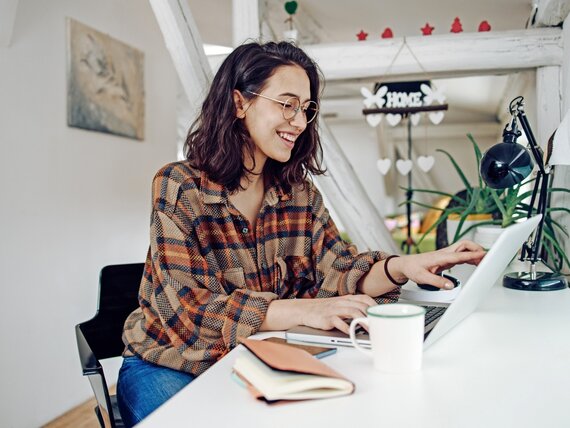 Eine Frau im Homeoffice arbeitet am Laptop.