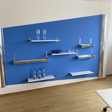 blau weiße Wand mit regalen und Wasserkaraffen und Wasserflaschen mit Gläsern