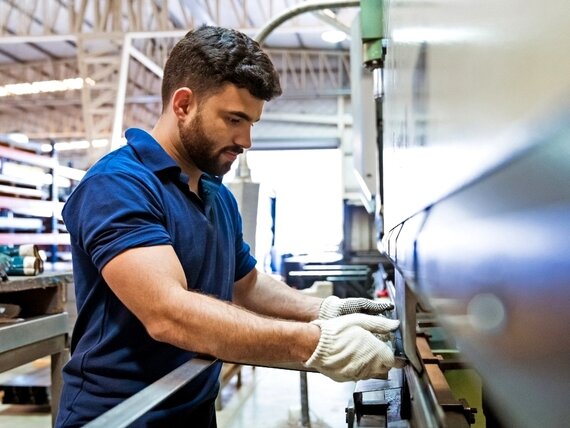 Ein Mann mit Schutzkleidung arbeitet an einer Maschine