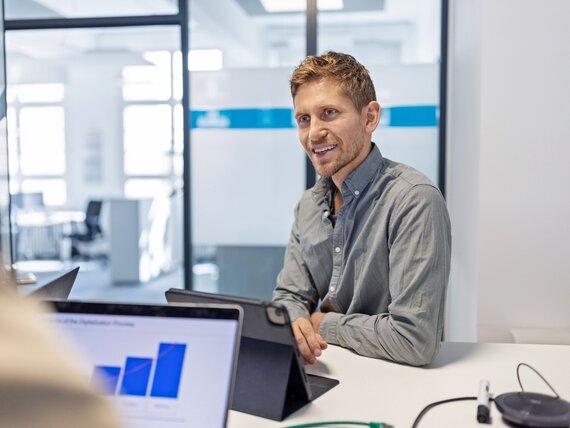 Ein Mann mit Tablet befindet sich in einem Meeting im Büro