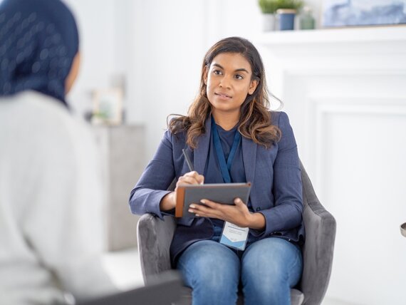 Eine Frau mit Hijab nimmt an einem Beratungsgespräch bei einer anderen Frau teil.