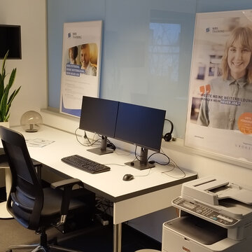 PC-Arbeitsplatz mit zwei Monitoren, Tastatur, Maus und Headset.