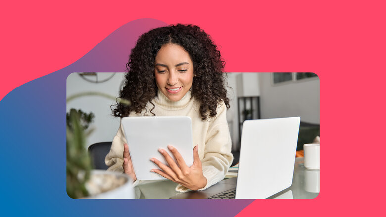 Frau mit dunklen Locken sucht nach Jobs am Tablet im Home Office