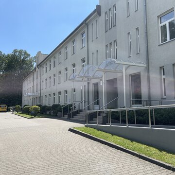 Ein dreistöckiges Gebäude und eine gepflasterte Straße.