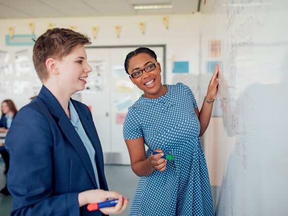 Zwei Frauen erarbeiten gemeinsam einen Plan am Whiteboard.