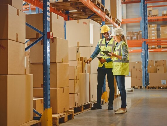 Eine Frau und ein Mann überprüfen die Ware in einem Lager