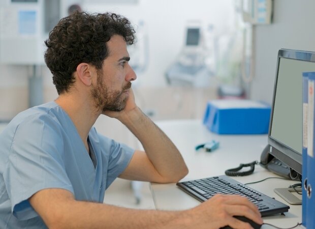 Ein medizinischer Fachangestellter schaut sich etwas am Computer an