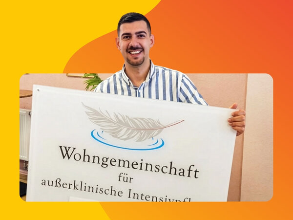 Lächelnder Mann mit gestreiftem Hemd hält Schild mit der Aufschrift 'Wohngemeinschaft für außerklinische Intensivpflege' in den Händen