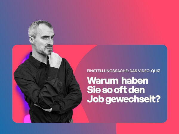 Ein Mann mit schwarzem Hemd hat die Arme verschränkt und schaut skeptisch in die Kamera.