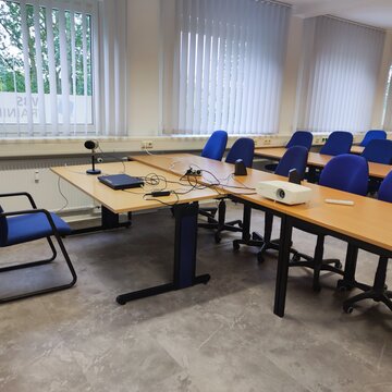 Lehrerplatz im Schulungsraum mit einem Laptop und Beamer.
