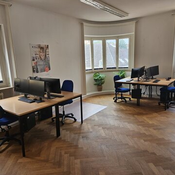 Geräumiger Schulungsraum mit mehreren Computerarbeitsplätzen.