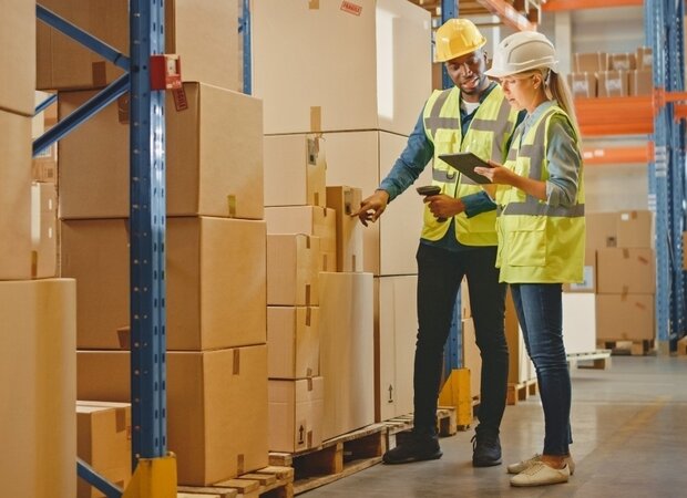 Eine Frau und ein Mann überprüfen die Ware in einem Lager