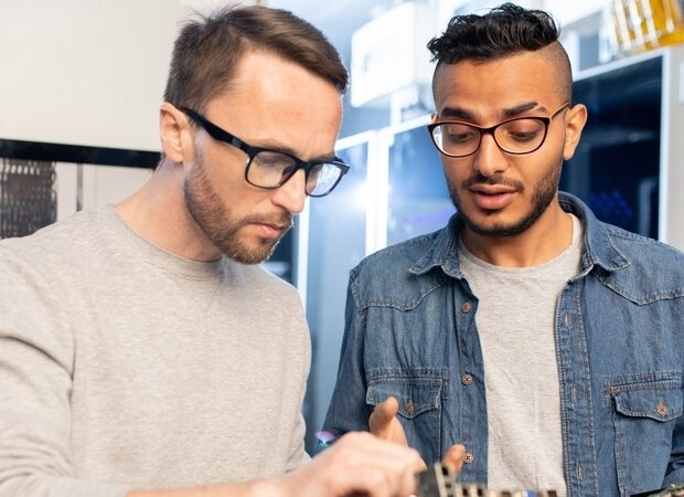 2 Männer arbeiten an Computern und Servern.