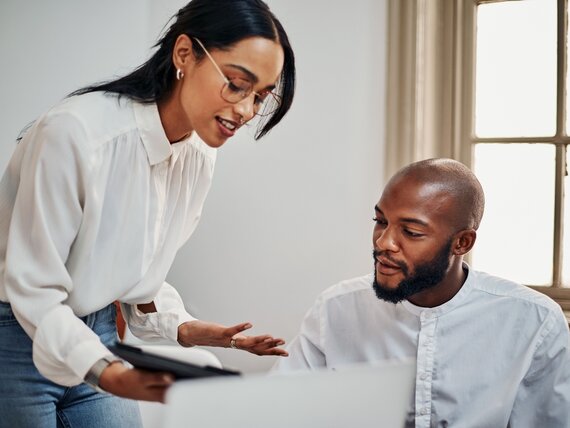 Ein Mann und eine Frau schauen sich Unterlagen an.