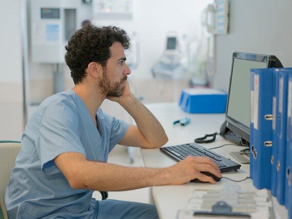 Ein medizinischer Fachangestellter schaut sich etwas am Computer an