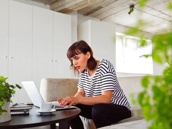 Eine Frau im Homeoffice arbeitet an ihrem Laptop.