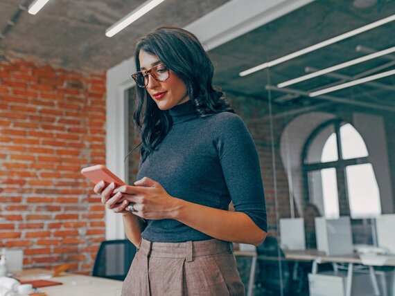 Eine Frau tippt etwas auf ihrem Smartphone.