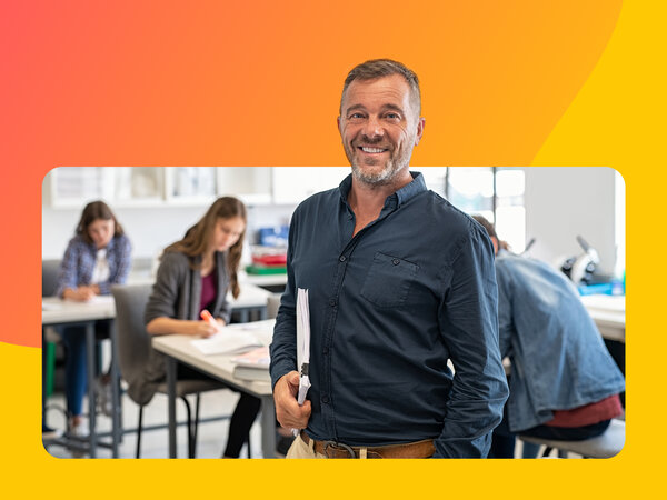 Mann mittleren Alters steht vor Schüler:innen in einem Unterrichtsraum.