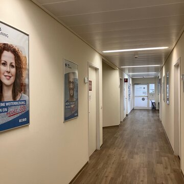 Langer Flur zum Haupteingang mit Bilder an den Wänden