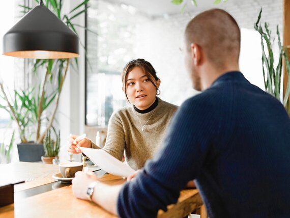 Eine Frau und ein Mann unterhalten sich über Unterlagen.