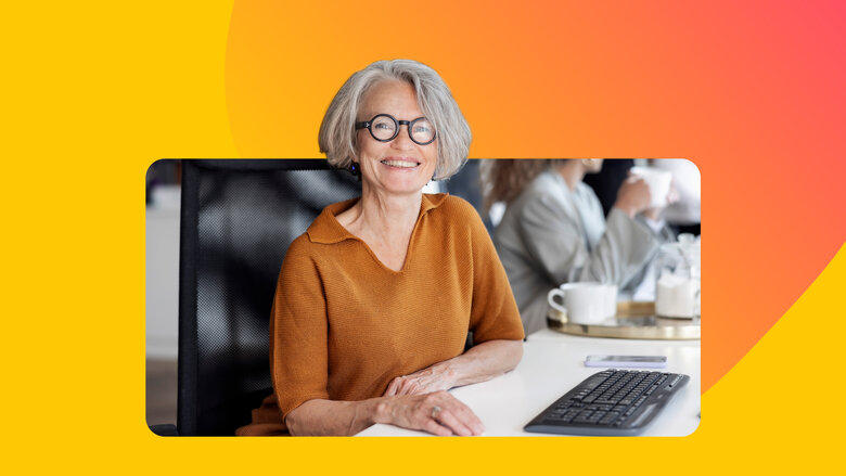 Seniorin mit Brille sitzt an Computer und lernt