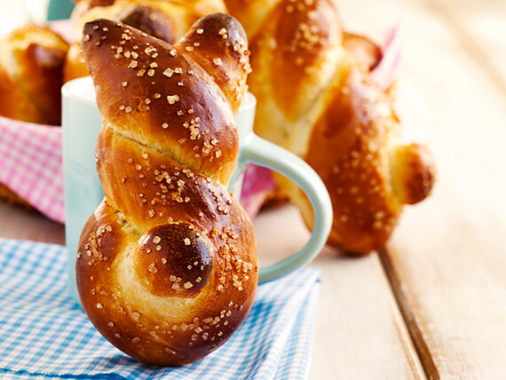 ein frisch gebackenes Hasenbrötchen, an eine Tasse gelehnt.