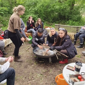Schüler:innen während eines Wandertages am Lagerfeuer.