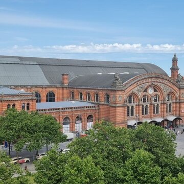 Blick aus dem Fenster auf das Bahnhofsgelände mit einem schönen, großen Gebäude.