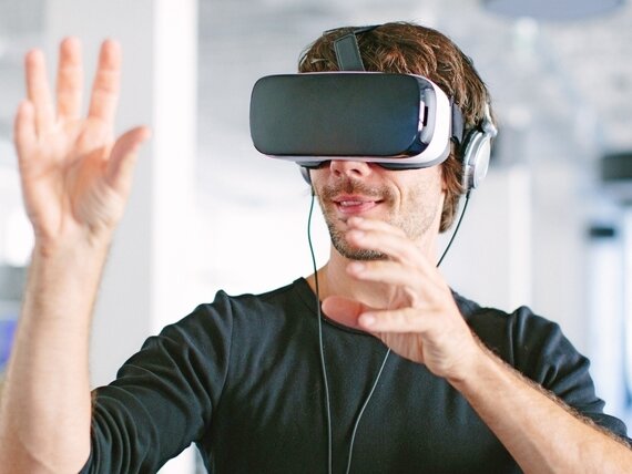 Ein junger Mann im Büro mit VR-Brille.