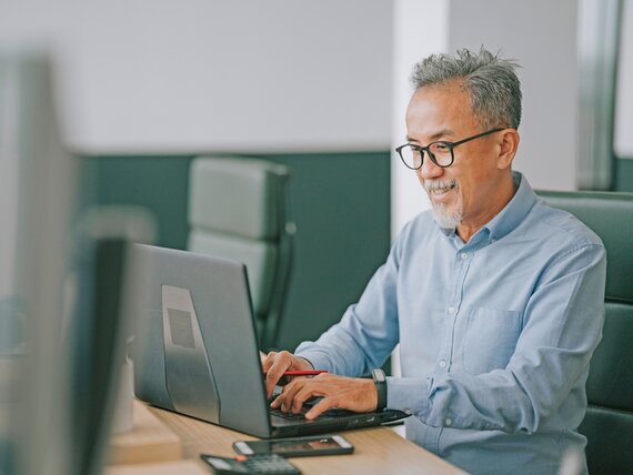 Ein Mann im mittleren Alter arbeitet an seinem Laptop.