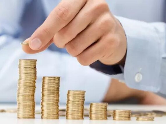 Münzstapel mit Hand für Mitarbeiterförderung.