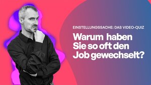 Ein Mann mit schwarzem Hemd hat die Arme verschränkt und schaut skeptisch in die Kamera.