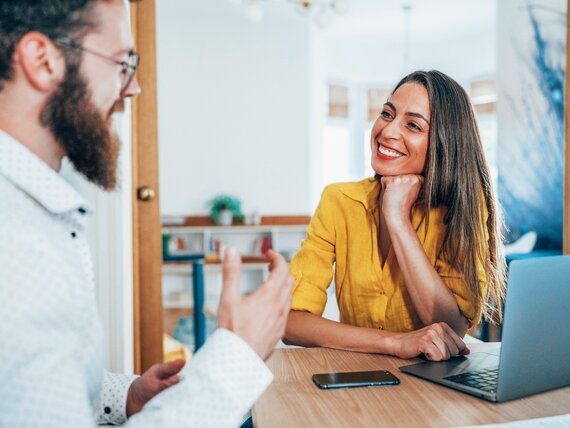 Eine Frau und ein Mann unterhalten sich im Büro.