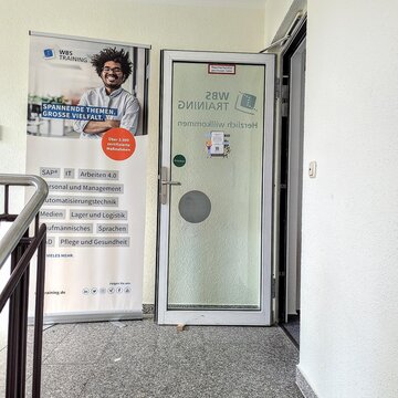 Eingangsbereich in der ersten Etage zu WBS TRAINING mit Roll Up Banner
