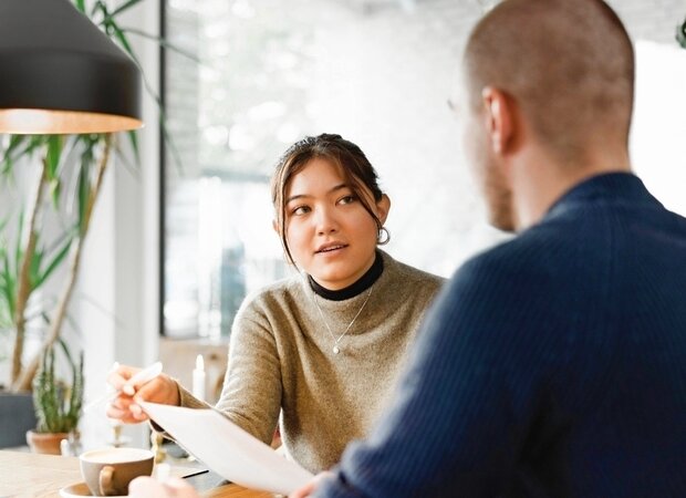Eine Frau und ein Mann unterhalten sich über Unterlagen.