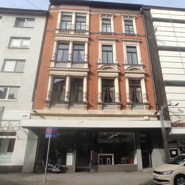 Frontansicht vom Standortgebäude. Backstein Fassade, Ladenlokal im Erdgeschoss.