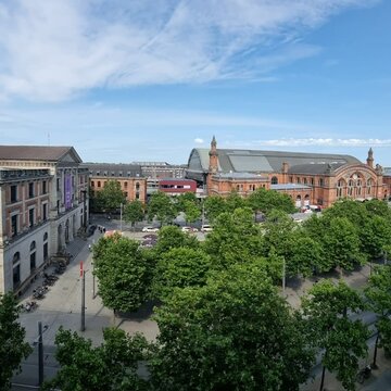 Blick aus dem Fenster auf das Bahnhofsgelände mit einem schönen, großen Gebäude.
