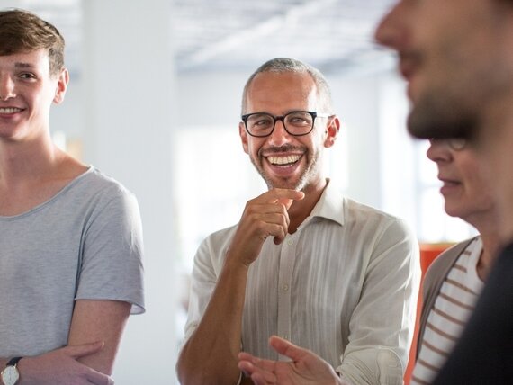 Eine Gruppe Männer und Frauen unterhalten sich fröhlich.