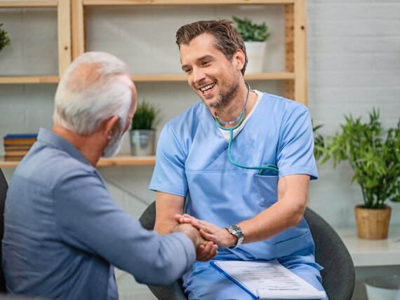 Ein junger Arzt kümmert sich fürsorglich um einen Senior