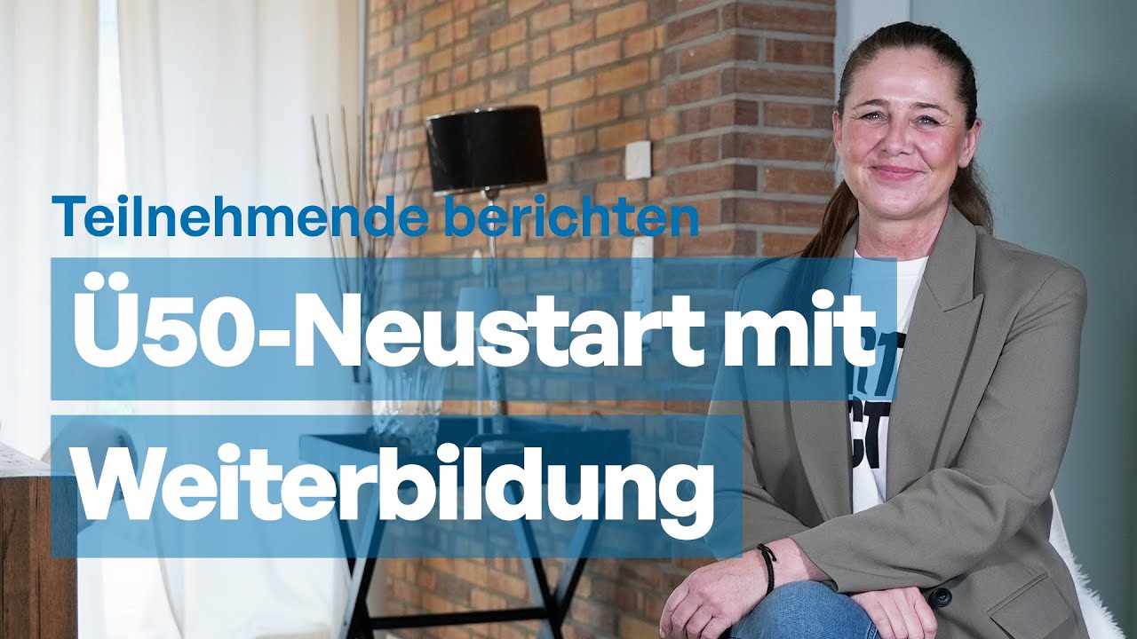 Eine lächelnde Ü50-Frau im Blazer vor einer Backsteinwand